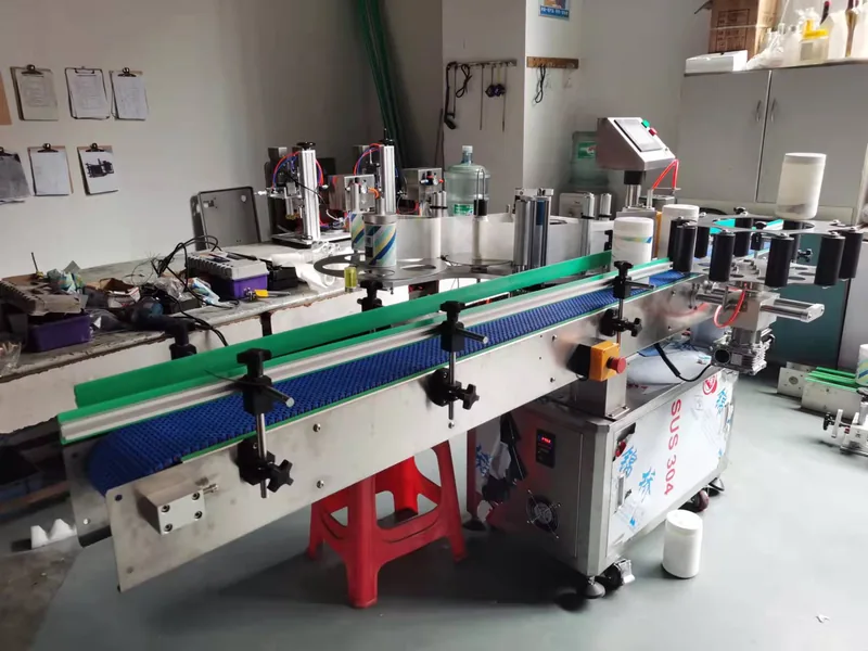 Company-owned photo of small pitch chain conveyor labeling machine company view, catalog view 114.